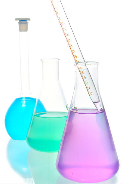 istock Volumetric laboratory glassware containing colored liquids isolated over white background 463375347