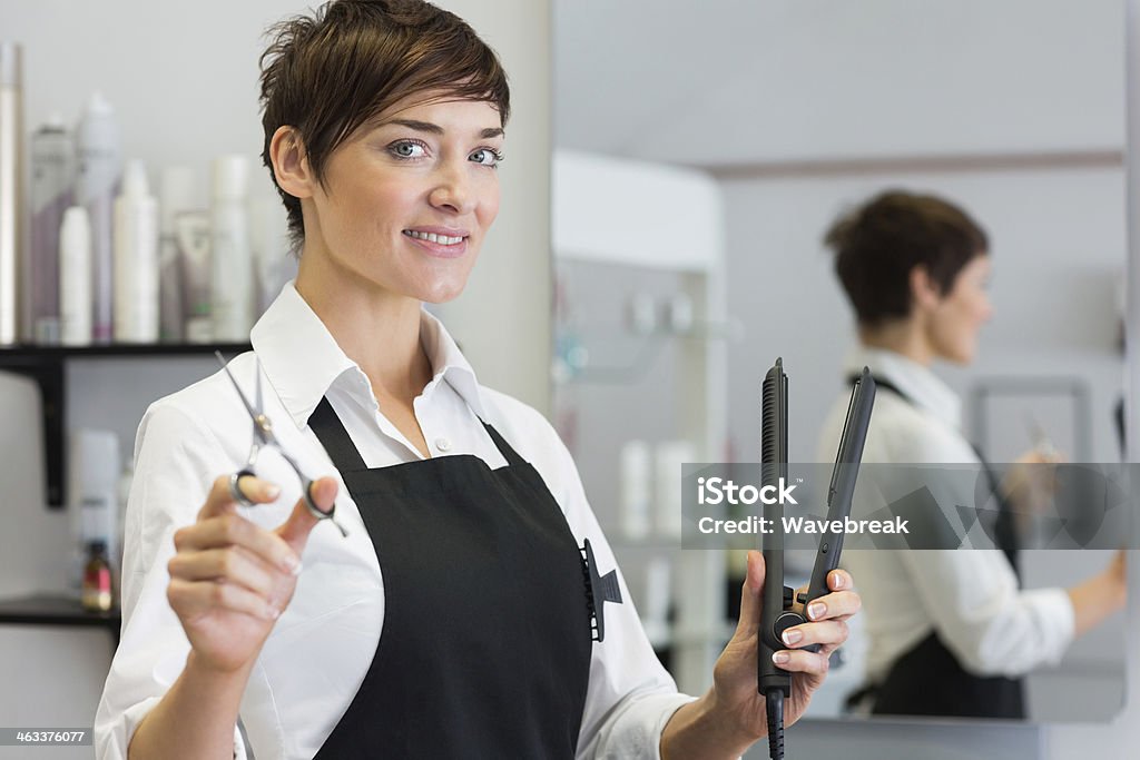 Female hairdresser holding scissors and hair straightener - Zbiór zdjęć royalty-free (30-39 lat)