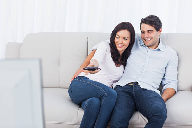 istock Woman changing tv channel next to her husband 463376801