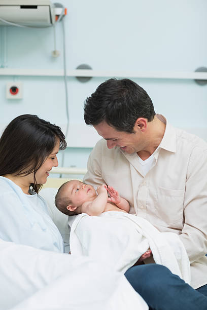 istock Smiling father and mother holding a baby 463377477