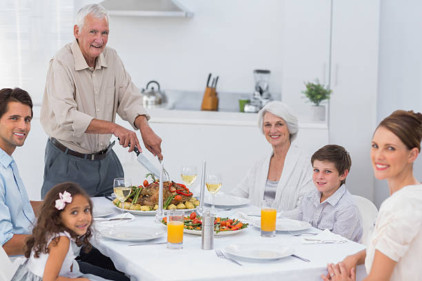 istock Elderly man carving roast chicken 463377617