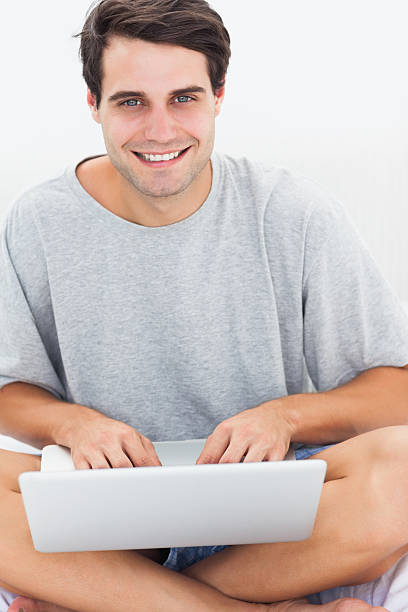 istock Portrait of a man using laptop on bed 463378861