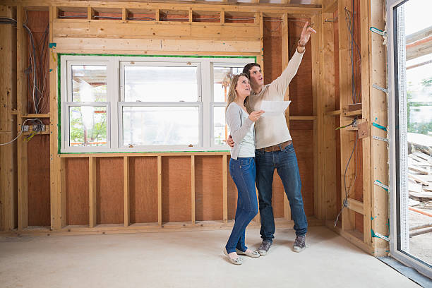 istock Couple standing in house site with man pointing 463383307