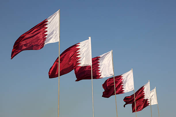 istock Six national flags of Qatar on a sunny day 463385917