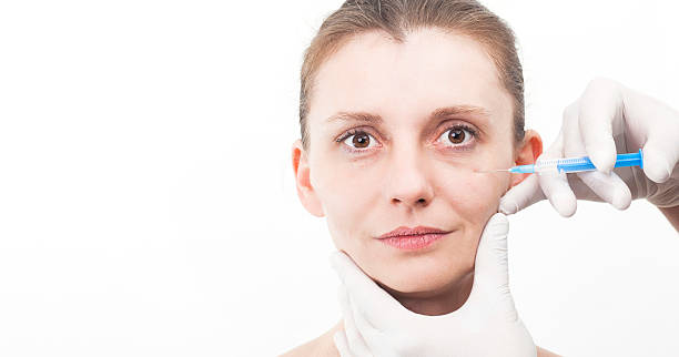 istock Woman getting botox injection to remove eye wrinkles 463397487