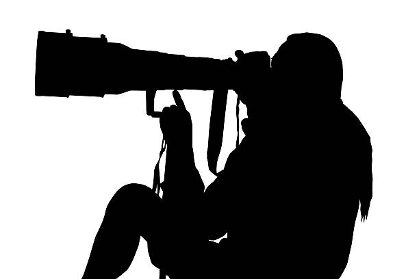 istock Silhouette of Photographer Sitting with Large Lens 463403241