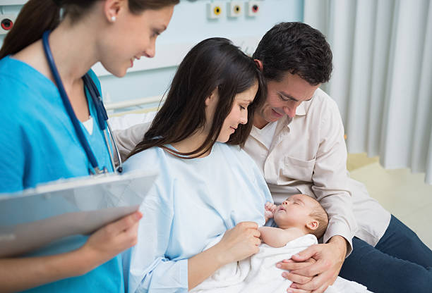 istock Doctor looking at parents holding a baby boy 463403267