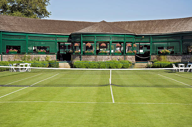 A grass tennis court with pavilion in the background stock photo