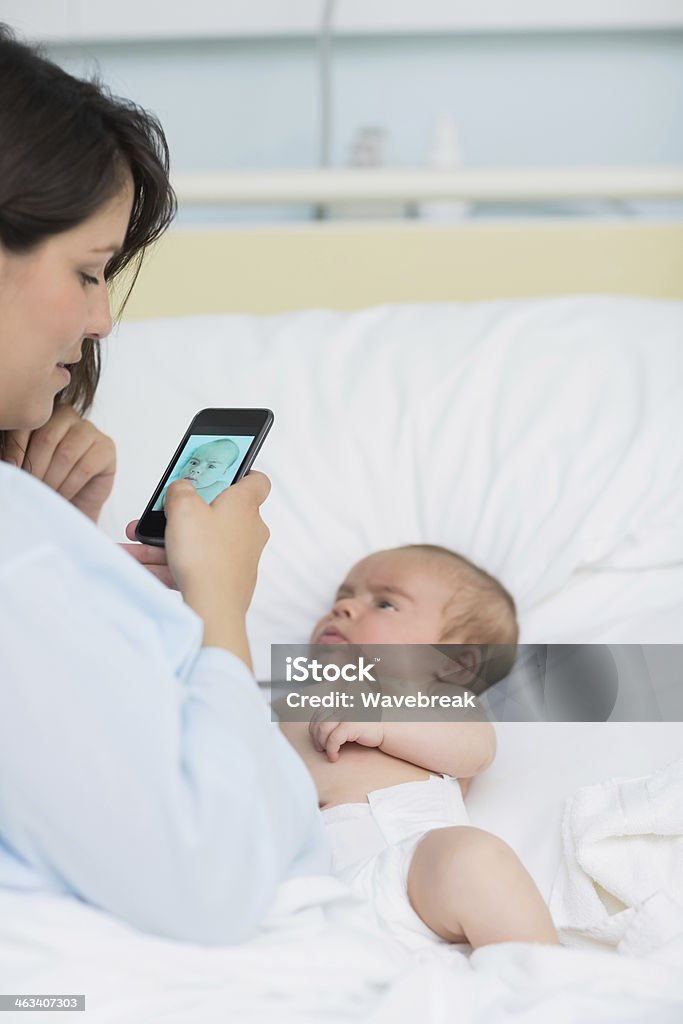 Mulher tirando uma foto de seu bebê recém-nascido - Foto de stock de 30 Anos royalty-free