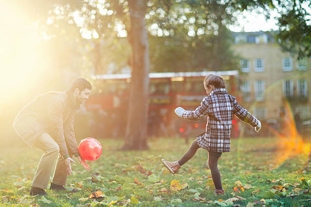 istock Daughter  and Father playing with ball In A Park 463407855