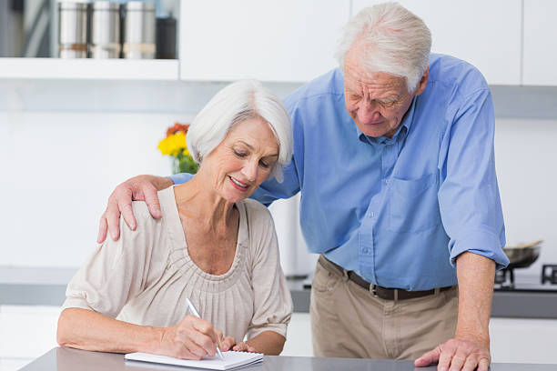 istock Retired man looking at his wife writing on notebook 463408015