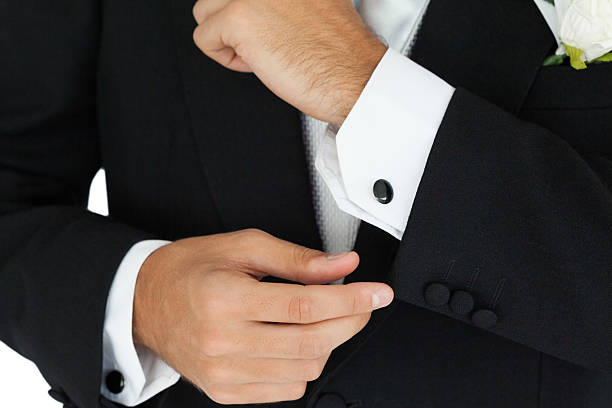 istock Close up of a classy groom buttoning his cufflinks 463408585
