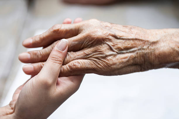 istock Close-up of a young hand holding an elderly hand 463409659