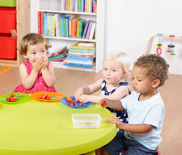 istock Group Of Toddlers Enjoying Mealtime In A Nursery Setting 463410341