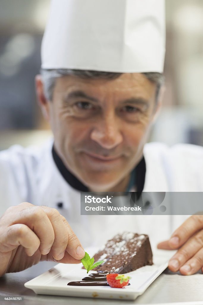 Chef adicionando folha de menta para prato de sobremesa - Foto de stock de 50 Anos royalty-free