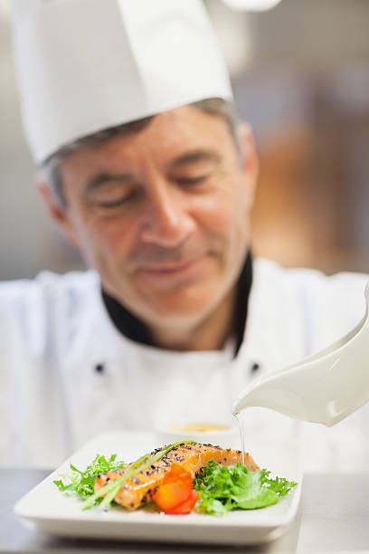 istock Chef pouring sauce over salmon dish 463410785