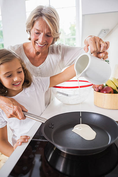 istock Granny and little girl making pancakes 463411221