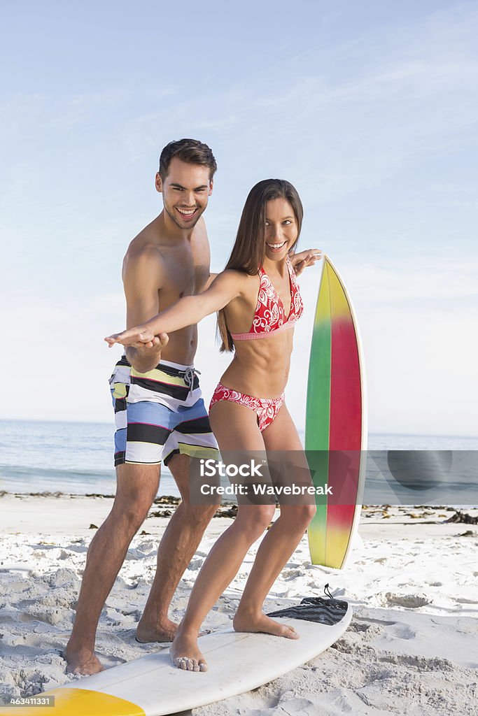 Man teaching a woman how to surf - 로열티 프리 20-29세 스톡 사진