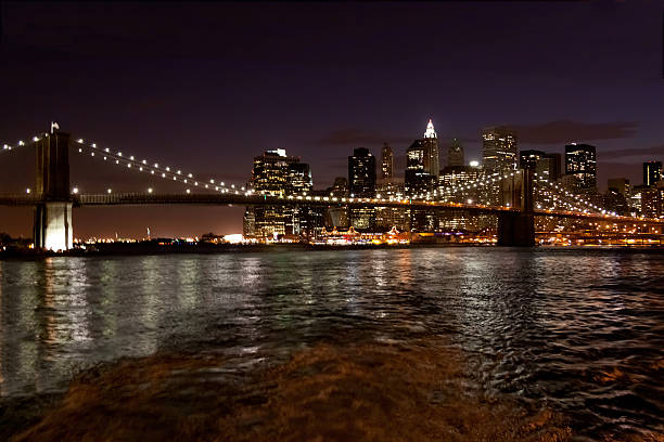 ブルックリン橋夜には、ニューヨークシティー。 - east river riverbank waters edge suspension bridge ストックフォトと画像