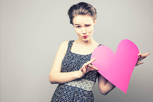 giovane donna con cuore flirtare - capelli cotonati foto e immagini stock