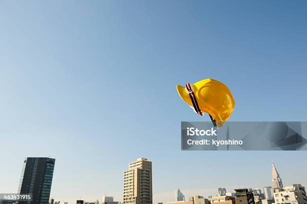 黄色工事用ヘルメットフライング中旬に Air アゲインスト澄んだ空 - ヘルメット類のストックフォトや画像を多数ご用意 - ヘルメット類, 建設現場, カラー画像