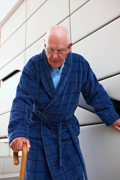istock Senior man walking down stairs with cane 463439973
