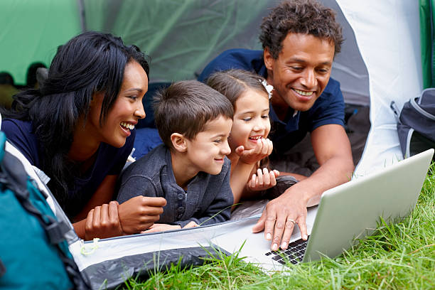 istock Family inside camping tent surfing internet on laptop 463445481