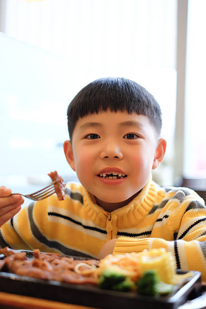 istock Asian boy in a restaurant steak 463448937