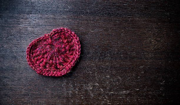 istock Knitted red heart on a wood background 463449271
