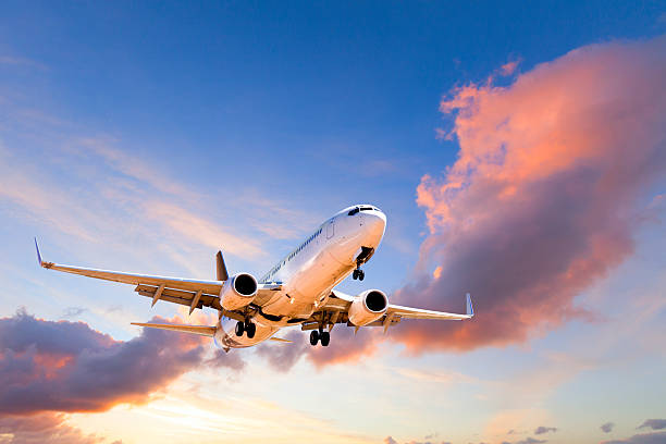 aeroplane coming in to land at sunset - vliegen stockfoto's en -beelden