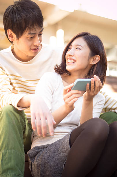 istock young couple is playing in the smartphone (Japanese couple) 463461297