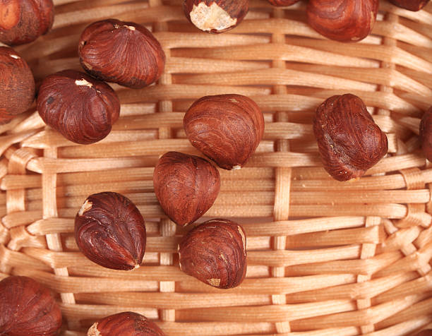 close-up de hazel nozes em uma cesta de vime. - hazelnut nut hazel tree tree - fotografias e filmes do acervo