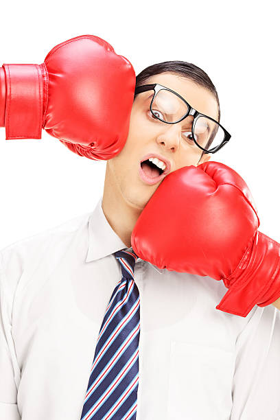 istock Young man with glasses punched by two red boxing gloves 463464001
