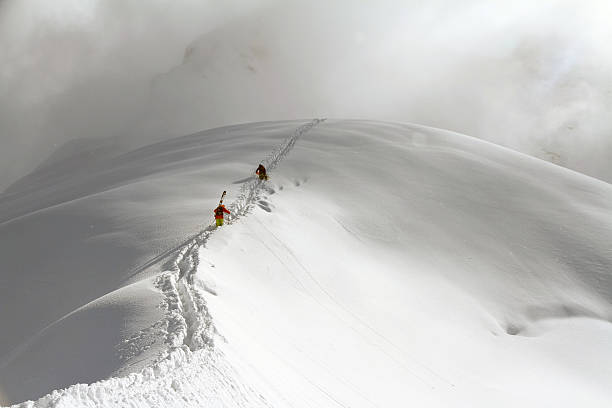 istock Skiers climbing a snowy mountain 463469197