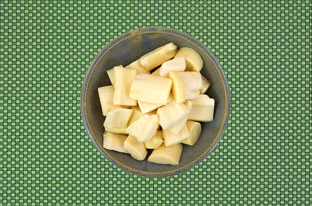 Canned palm hearts in an old bowl A bowl of canned palm hearts on a green patterened background. palm heart photos stock pictures, royalty-free photos & images