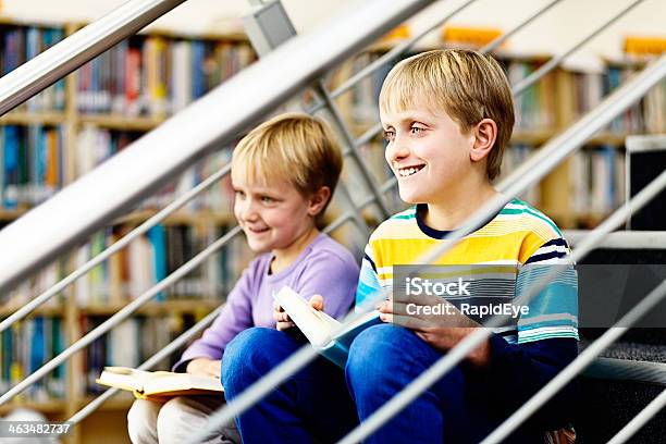 Foto de Sorrindo Irmãos Sentese Na Biblioteca Com Livros De Passos e mais fotos de stock de 10-11 Anos