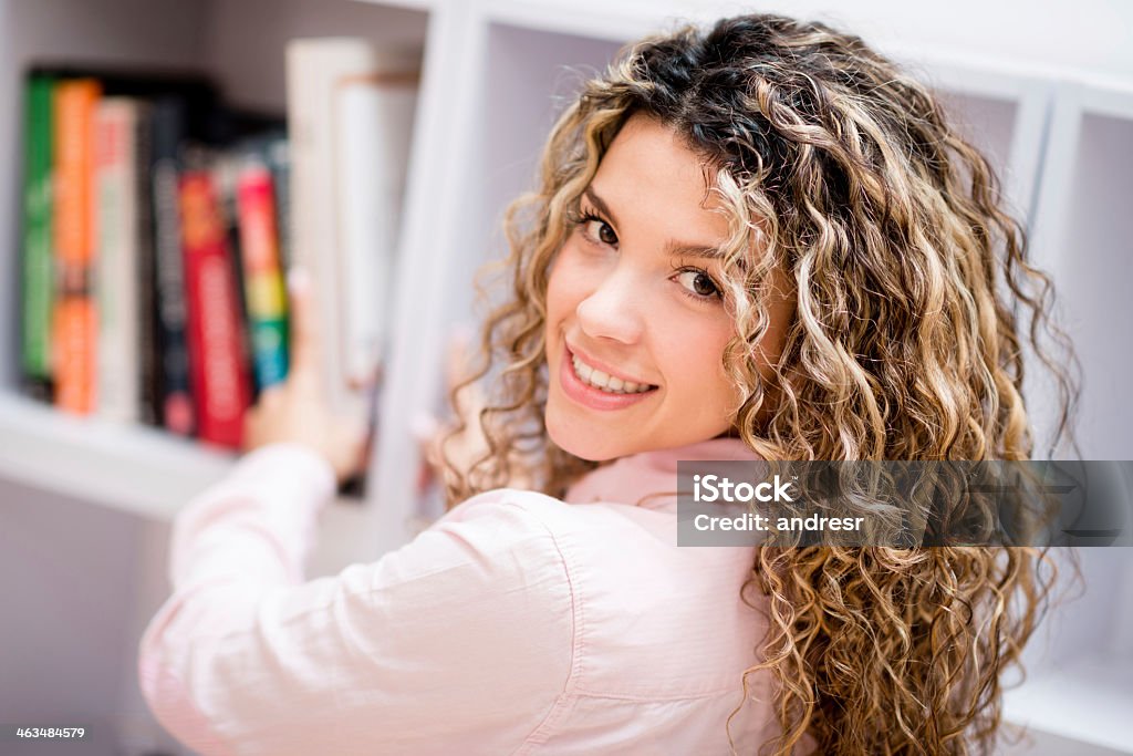 Woman organizing her home Happy woman organizing books at her home 20-29 Years Stock Photo