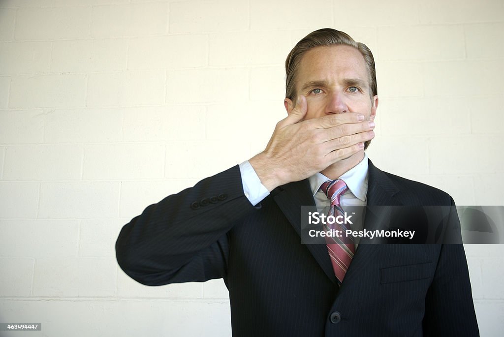 Uomo d'affari con la mano sulla bocca - Foto stock royalty-free di Affari