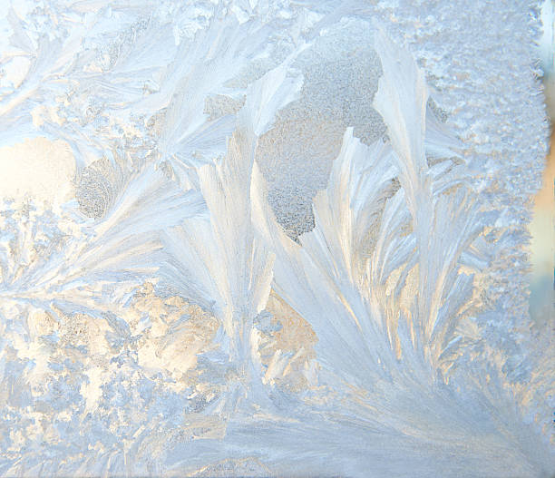 Closeup of clean and thin-looking ice with varying textures Frosty pattern at a winter window glass icicle snowflake winter brilliant stock pictures, royalty-free photos & images