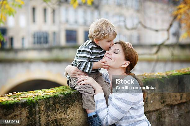 Adorable Little Son And Mother In Autumn City Stock Photo - Download Image Now - Embracing, Street, 12-17 Months