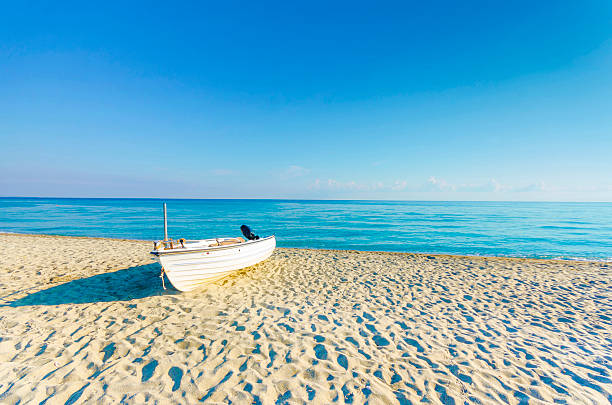 istock Boat on empty sea beach and horizon at sunrise 463513383