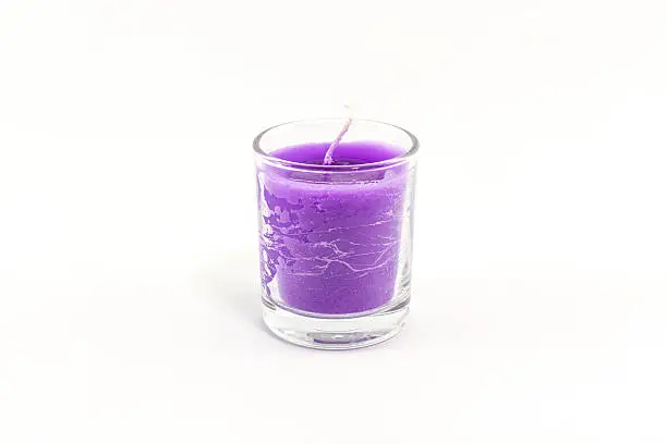 Beautiful colorful candle in glass isolated on white background.