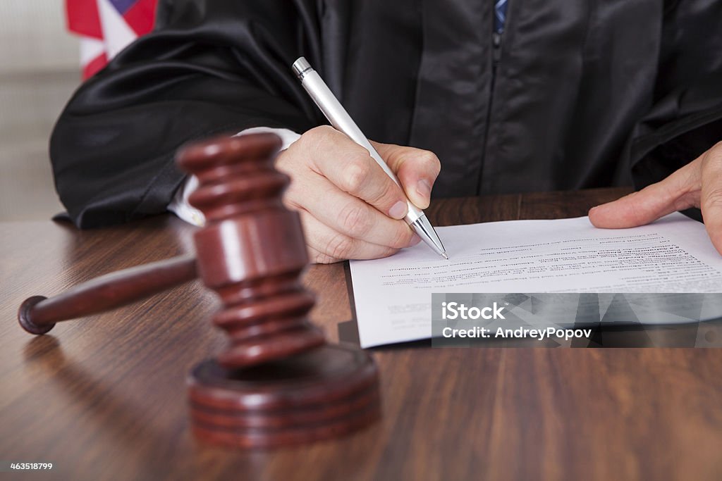 Male Judge Writing On Paper Close-up Of Male Judge  Writing On Paper In Courtroom Judge - Law Stock Photo