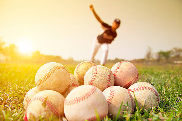 giocatori di baseball pitching per esercitarsi al di fuori - baseballs baseball grass sky foto e immagini stock