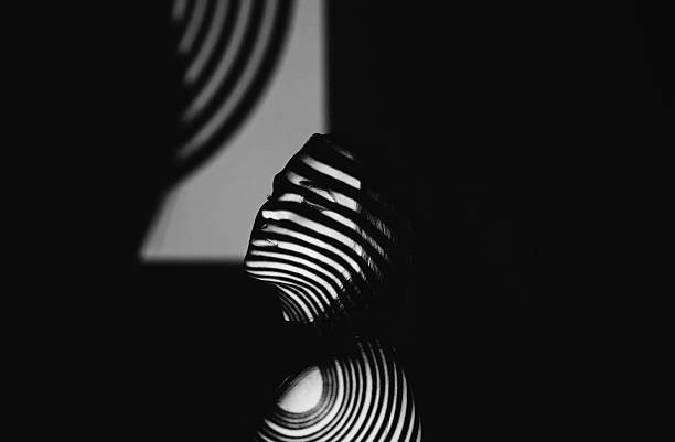 Monochrome studio shot of a woman with patterns projected onto her