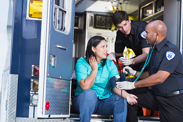 Paramedics helping a patient Multi-ethnic paramedics helping Hispanic woman. medic stock pictures, royalty-free photos & images
