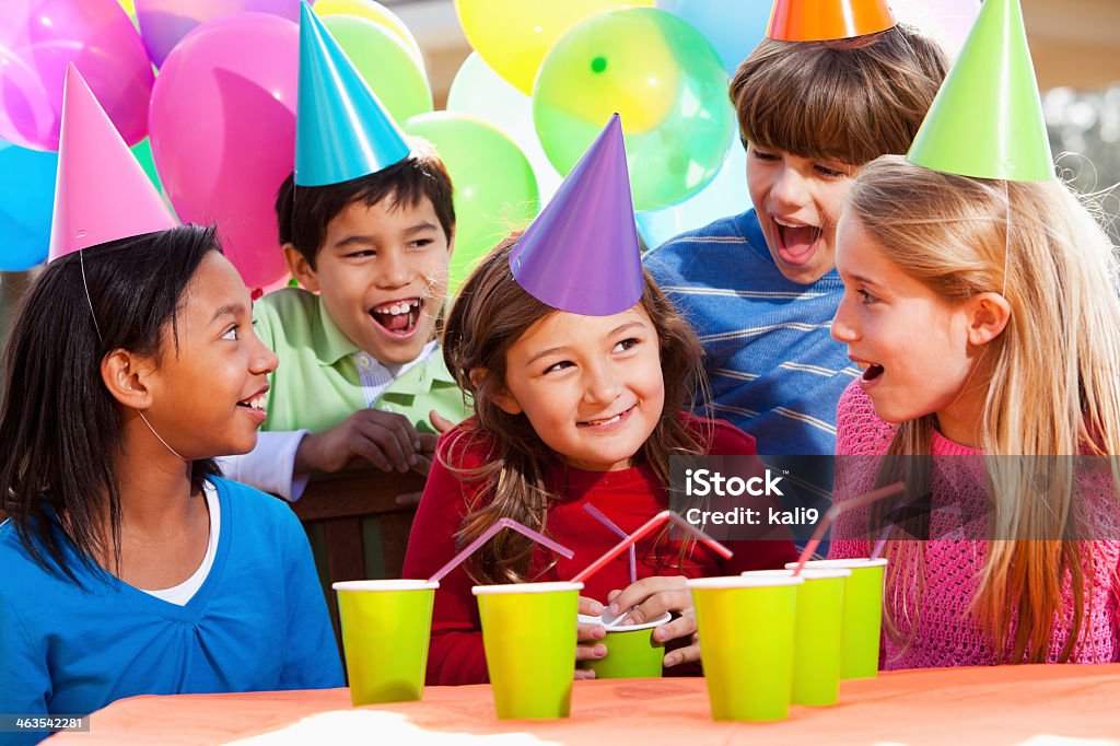 Children at birthday party Multi-ethnic children (7-10 years) having fun at birthday party.  (Hispanic boy, back left, is not in focus). 10-11 Years Stock Photo