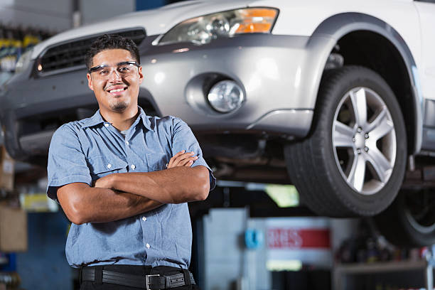 Auto mechanic Hispanic man (20s) working in auto repair shop. car mechanic top view stock pictures, royalty-free photos & images