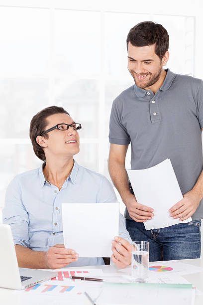 fazer alguns documentos. - polo shirt two people men working imagens e fotografias de stock