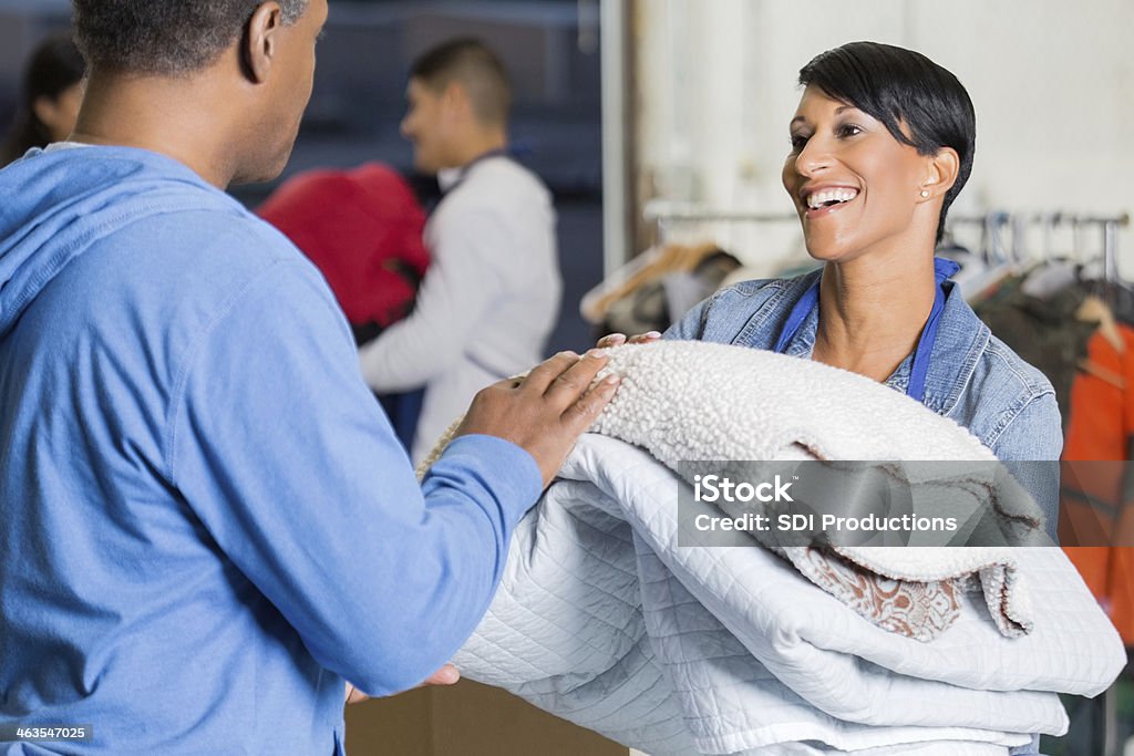 Fêmea voluntário dando doado cobertores de vítimas de catástrofes - Royalty-free Doação caridosa Foto de stock